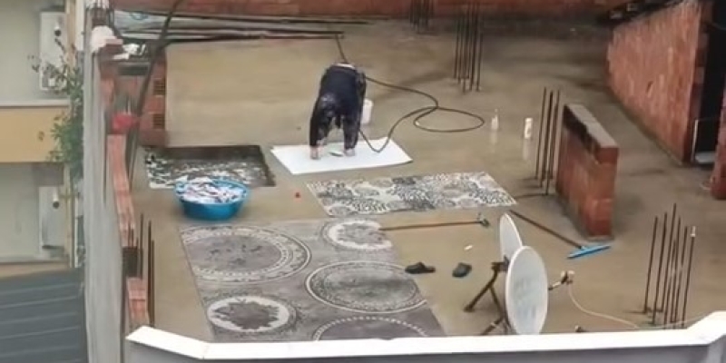 Yağmurlu havada çatıda halı yıkadı, görenler şaştı kaldı